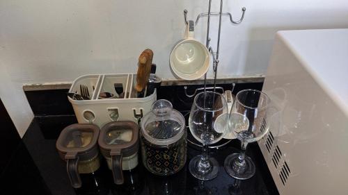 a group of wine glasses and a sink on a counter at A lovely studio apartment with gym and pool access in Dar es Salaam