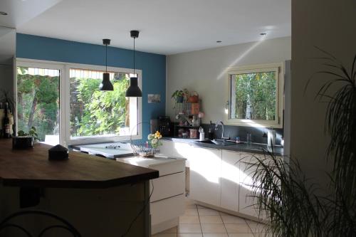 - une cuisine avec des placards blancs et des murs bleus dans l'établissement A la belle étape, à La Fouillouse