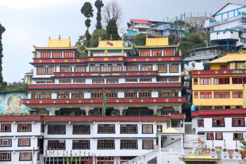 a large white building with red and yellow roofs at Vilasa Homestay in Darjeeling