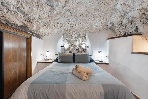 Schlafzimmer mit einem Bett mit Steindecke in der Unterkunft Cueva El Desvelo in Tijarafe