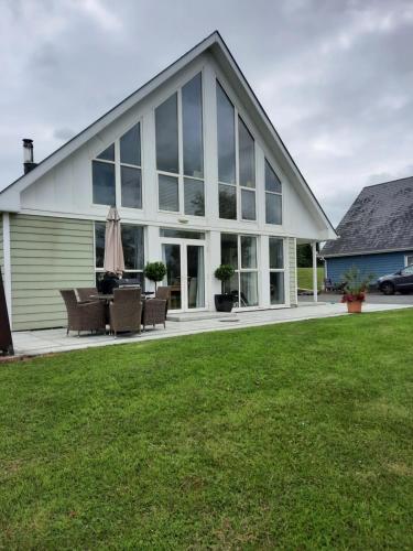 a large white house with windows and a lawn at 3 Bed-Sleeps 6-Pets-River View-Hot Tub in Belturbet
