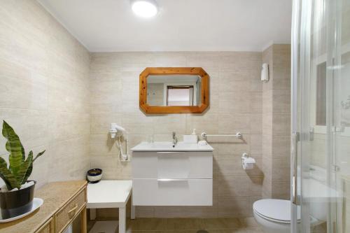 uma casa de banho com um lavatório, um WC e um espelho. em Casa Karma em Arico