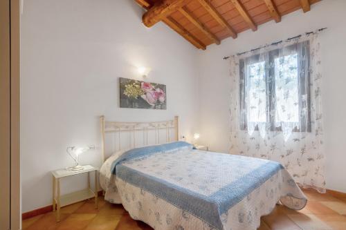 una camera da letto bianca con un letto e una finestra di Appartamenti i Tigli 2 a Capoliveri