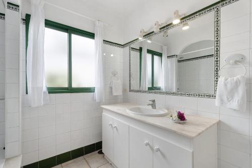La Villa La Palma- 2 dormitorios A في Los Barros: حمام أبيض مع حوض ومرآة