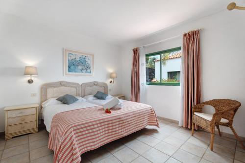 a bedroom with a bed and a chair and a window at Villa Verde Superior A in Los Barros