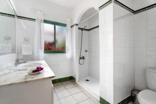 a white bathroom with a shower and a sink at Villa Verde Superior A in Los Barros