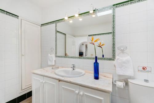 a white bathroom with a sink and a mirror at La Villa La Palma- 1 dormitorio A in Los Barros