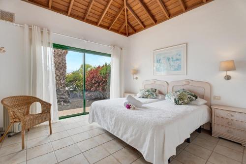 a bedroom with a bed and a large window at La Villa La Palma- 1 dormitorio A in Los Barros