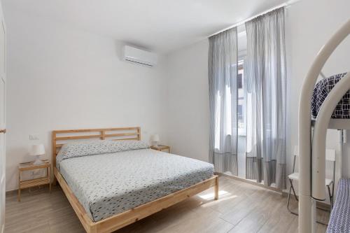 - une chambre avec un lit et une grande fenêtre dans l'établissement Appartamento 4, à Ameglia