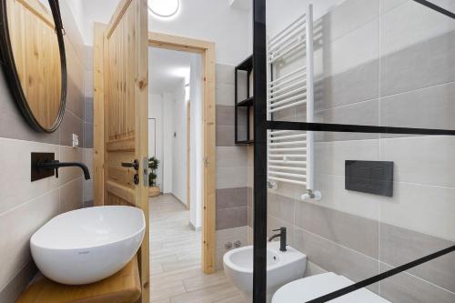 La salle de bains est pourvue d'un lavabo blanc et d'un miroir. dans l'établissement Appartamento 4, à Ameglia