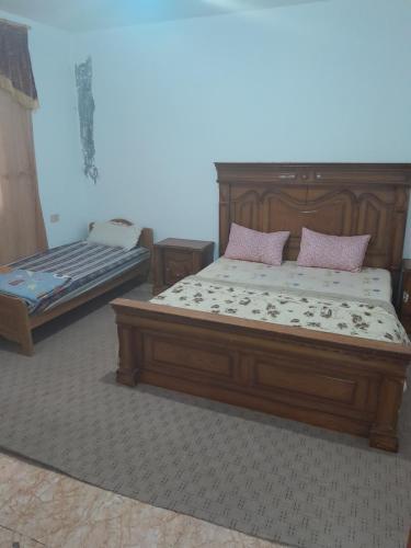 een slaapkamer met een groot bed en een bed sidx sidx sidx bij منزل ابو يوسف القضاه in Ajloun