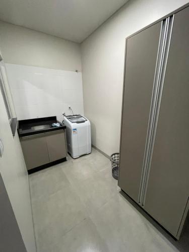 a small kitchen with a refrigerator in a room at Vêneto Flat Residence (AP-12) in Primavera do Leste