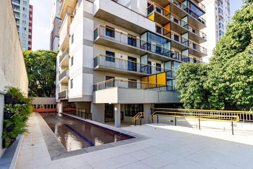 een appartementengebouw met een zwembad ervoor bij Xtay BK30 Santana - Apartamentos decorados próximos ao metrô in Sao Paulo