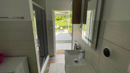a bathroom with a sink and a mirror at Naplemente Vendégház in Orfű