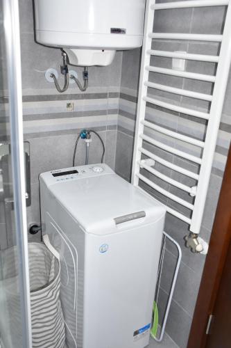 una lavatrice e asciugatrice in una piccola stanza con scala di Apartman Get Rest a Žabljak