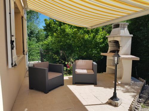 un patio con 2 sedie e stufa di Maison de campagne à Conie-Molitard (1h30 de Paris) a Conie-Molitard