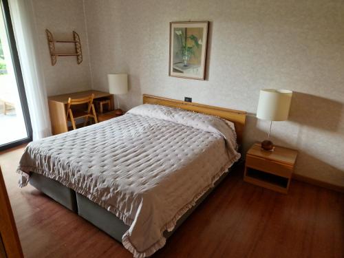 une chambre avec un lit, une table et une fenêtre dans l'établissement Happy Lake, à Desenzano del Garda