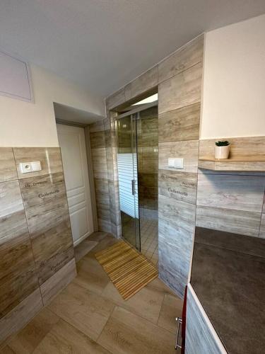 a bathroom with a shower with wooden walls at U Bocmana s výhledem na zámek a Labe in Děčín