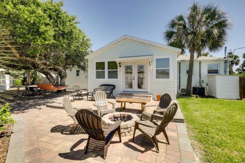 a patio with chairs and a table in front of a house at St Augustine Cottage with Fire Pit - Walk to Pier! in Saint Augustine Beach