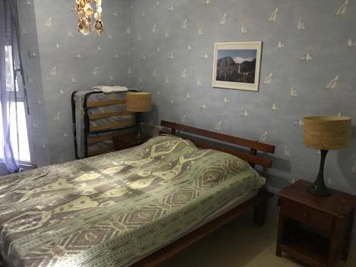 1 dormitorio con 1 cama y 1 mesa con lámpara en Première Ligne Avec Terrasse, en Mauguio