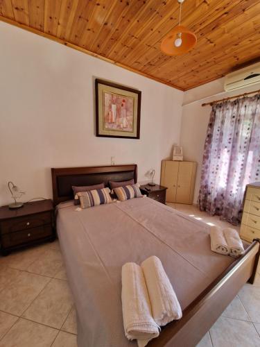 a bedroom with a large bed with two towels on it at Afroditi's 1 in Eresos