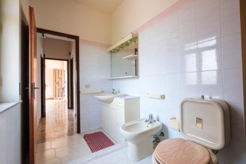 La salle de bains blanche est pourvue de toilettes et d'un lavabo. dans l'établissement Casa Stella vista Eolie, à San Pier Niceto