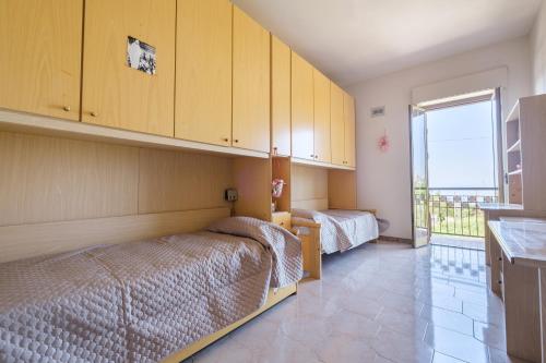 a bedroom with two beds and a large window at Casa Stella vista Eolie in San Pier Niceto