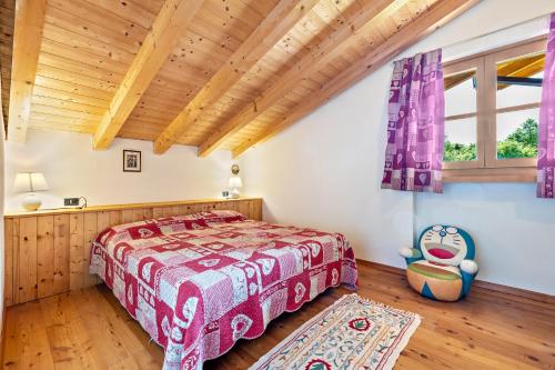 1 dormitorio con cama y techo de madera en Baita zia Mariota Zeller en Tione di Trento
