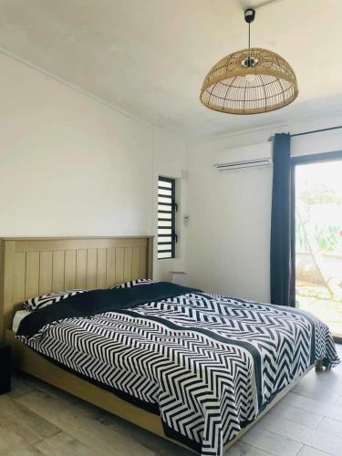 a bedroom with a black and white bed and a window at KAZELBA in Cap Malheureux