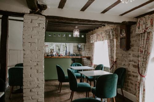 a dining room with tables and green chairs at Allington Manor in Allington