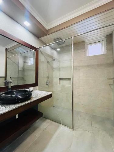 a bathroom with a glass shower and a sink at KAZELBA in Cap Malheureux