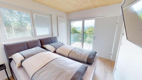 un sofá grande en una habitación con ventana en Modernes Ferienhaus mit Panoramablick en Rosegg