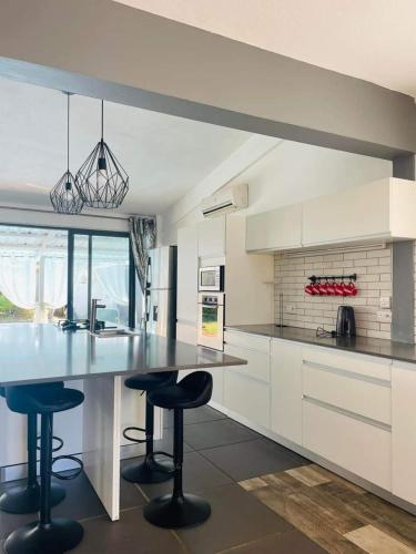 a kitchen with a large counter and stools in it at KAZELBA in Cap Malheureux