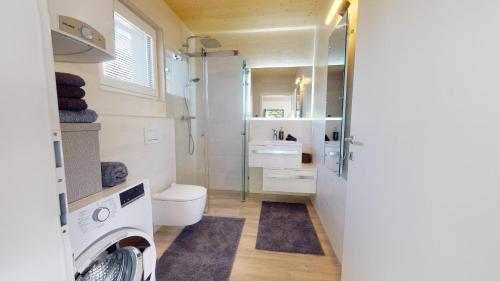 y baño con aseo, ducha y lavamanos. en Modernes Ferienhaus mit Panoramablick en Rosegg