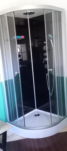 eine Dusche mit Glastür in einem Zimmer in der Unterkunft Chez Zabou in Rosières
