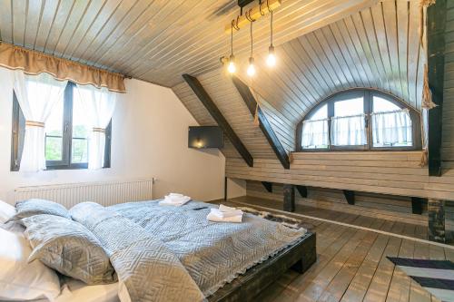 sypialnia z łóżkiem i drewnianym sufitem w obiekcie Old Cottage w mieście Bran