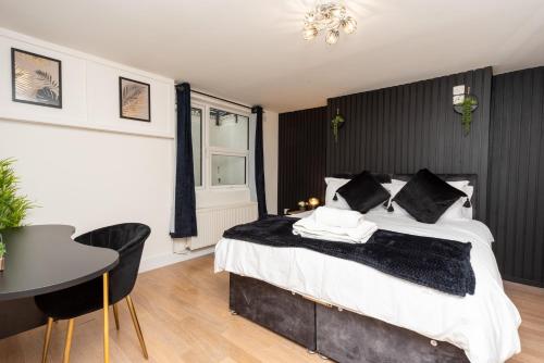 a bedroom with a large bed and a table and chairs at Free Parking Coastal Modern One Bedroom Apartment in Great Yarmouth