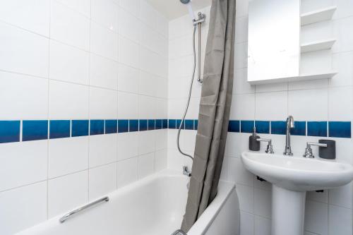 a white bathroom with a sink and a bath tub at Coastal Modern One Bedroom Apartment Free Parking in Great Yarmouth