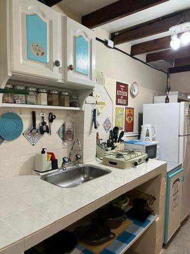 La cuisine est équipée d'un évier, d'une cuisinière et d'un réfrigérateur. dans l'établissement Departamento Cervantes, à Ushuaia