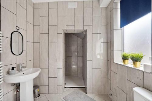 biała łazienka z prysznicem i umywalką w obiekcie Elegant Scandi Gem of Nottingham - Sleeps 10 w Nottingham