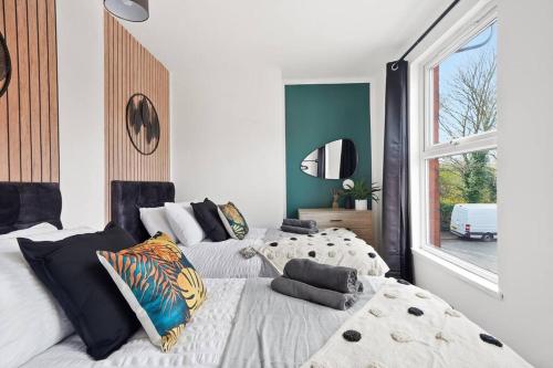 a bedroom with two beds and a large window at Elegant Scandi Gem of Nottingham - Sleeps 10 in Nottingham