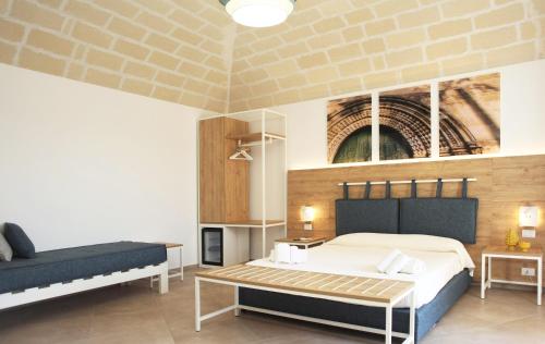 a bedroom with a large bed and a couch at Gli Archi garden rooms in Favignana