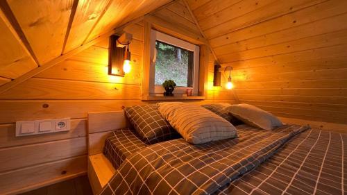a bed in a log cabin with a window at Cozyhouse in Slavske