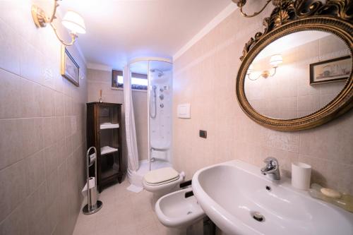 a bathroom with a sink and a toilet and a mirror at Trullo Leone in Martina Franca