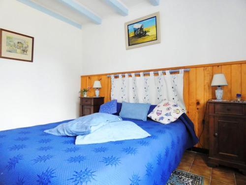 Luglon的住宿－Les tuileries，一间卧室配有蓝色的床和枕头