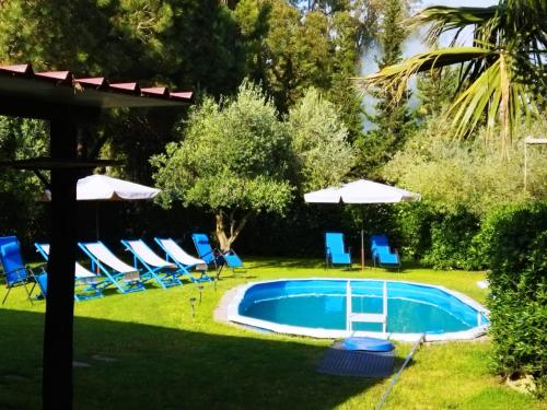 - une piscine dans une cour avec des chaises et des parasols dans l'établissement L'oasi del relax Arborea, à Arborea