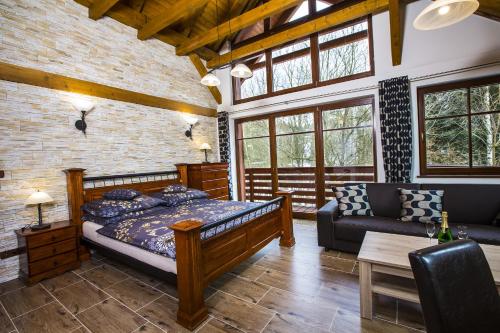 ein Schlafzimmer mit einem Bett und einem Sofa in der Unterkunft Apartmány Slunce in Harrachov