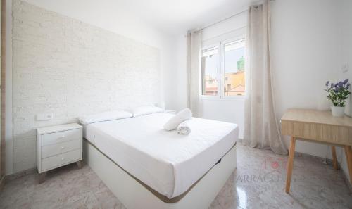 Habitación blanca con cama y ventana en TarracoHomes, TH134 Apartamento Llorer, en Tarragona