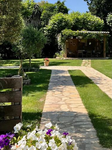 a walkway in a park with flowers in the grass at KIPOS-SS residences in Dassia