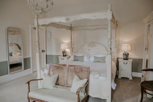 una camera con letto a baldacchino bianco e sedia di Allington Manor ad Allington